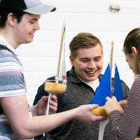 Students look at each other's boats